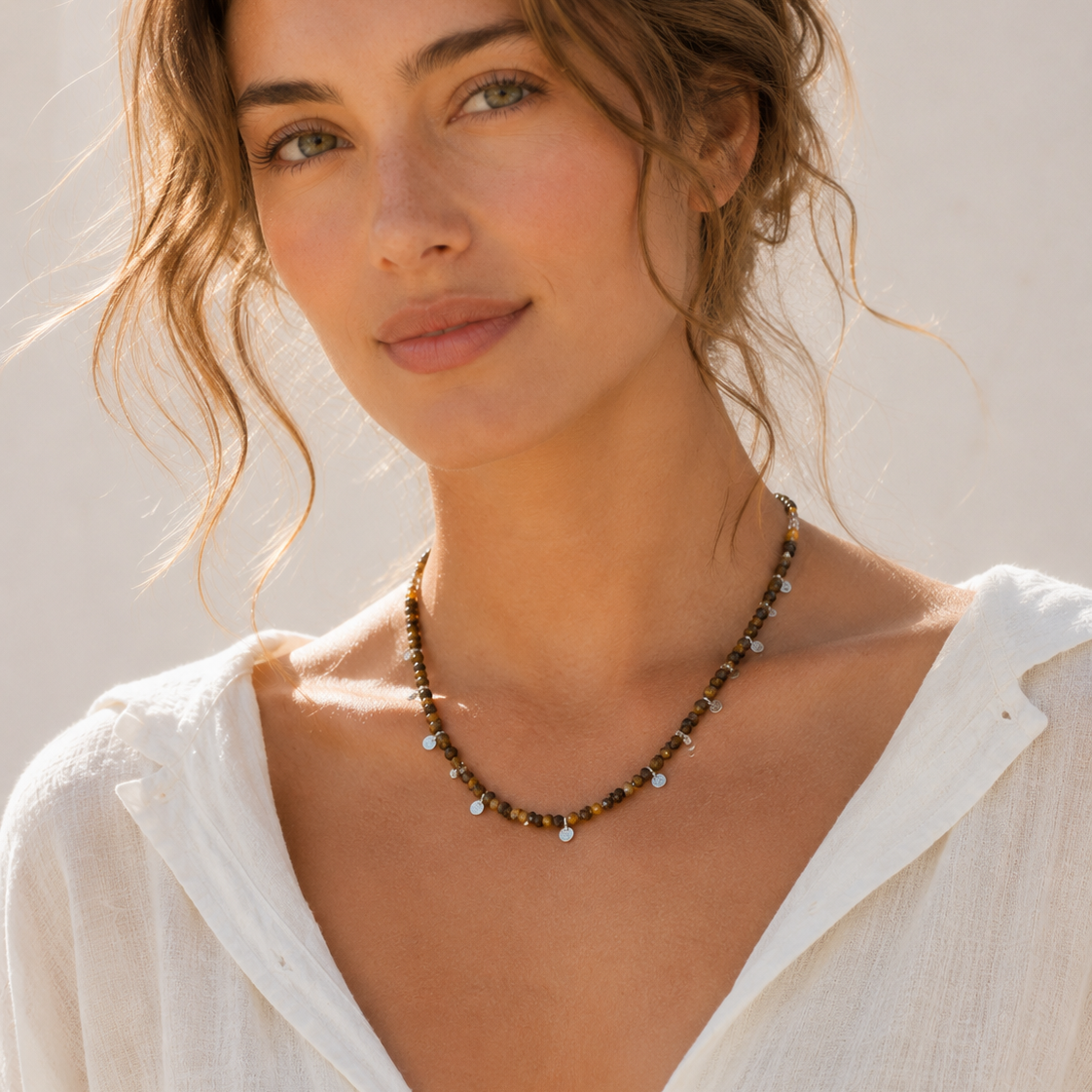 Model wearing Aurelia Tiger’s Eye Sterling Silver Charm Necklace with white linen summer outfit