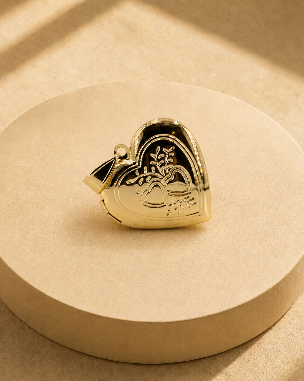 Angled front view of the Adora heart pendant showing the heart and leaf motif, polished border and bail.
