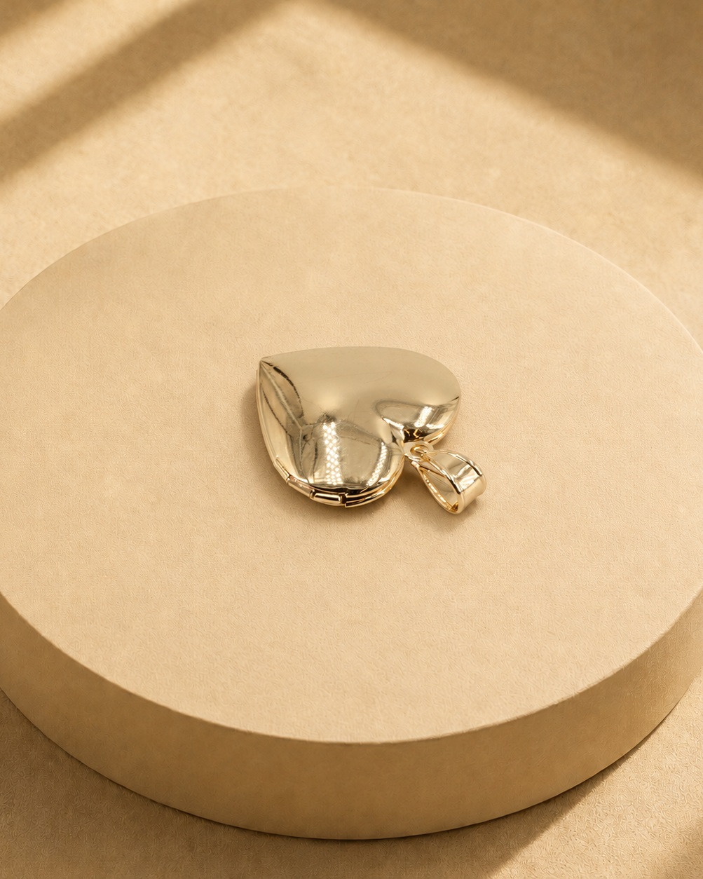 Back view of the Adora gold-plated heart pendant showing its smooth polished surface, edge seam and bail.