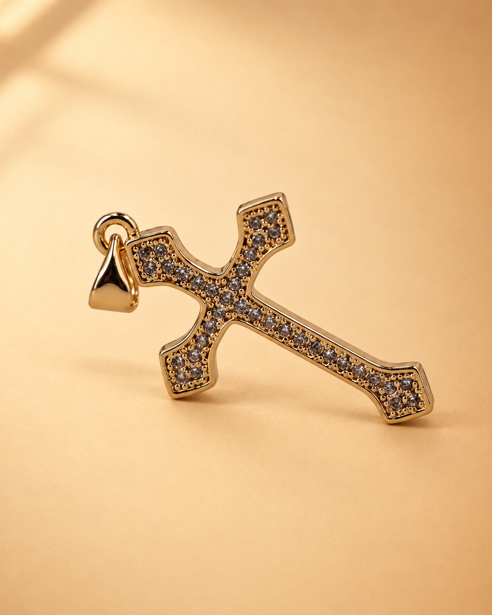 Clara cross pendant at an alternate angle, showing the rows of clear accents and smooth gold-plated border.