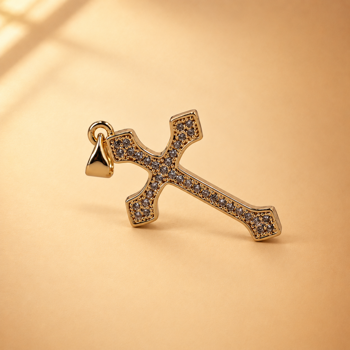 Clara cross pendant at an alternate angle, showing the rows of clear accents and smooth gold-plated border.