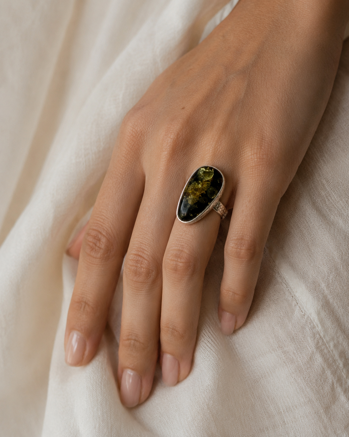 Close-up of golden flower amber botanical inclusions and textured sterling silver setting in Golden Flower Amber Sterling Silver Sculptural Ring