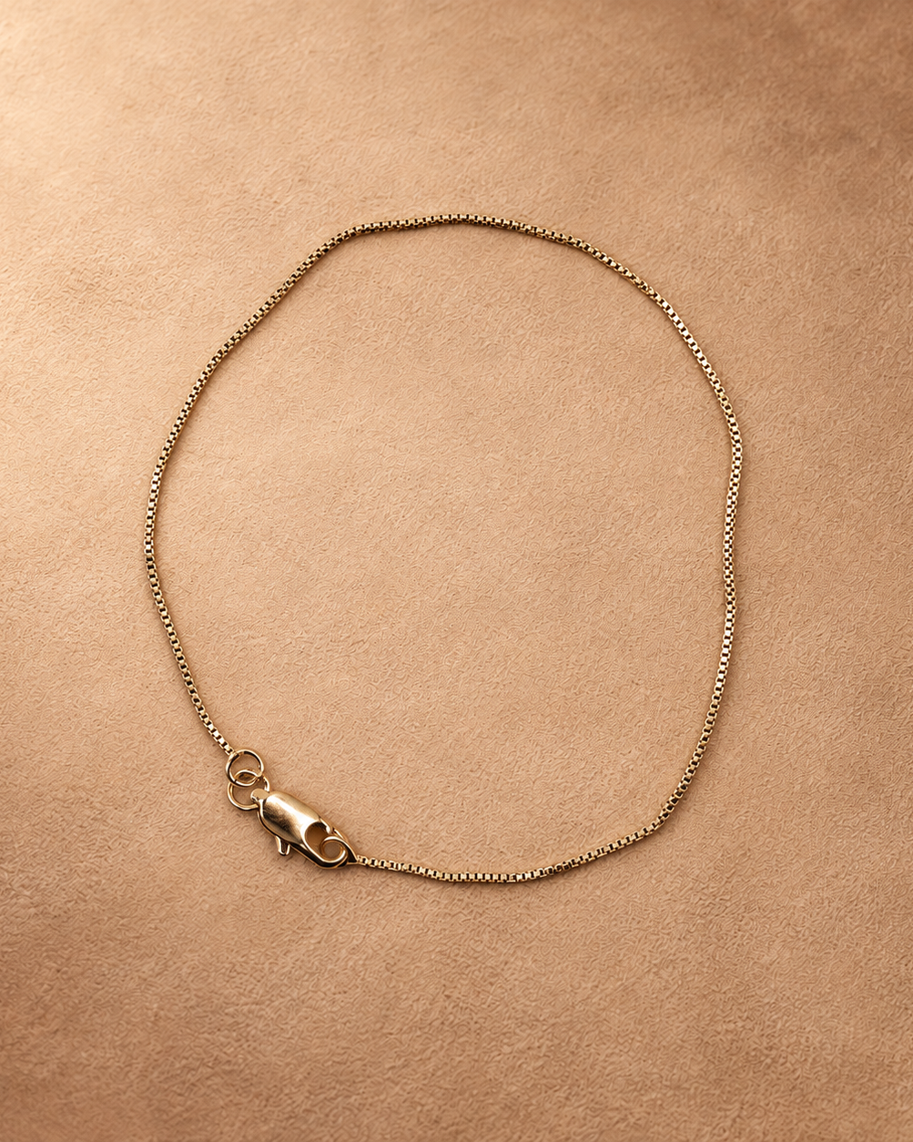 Linea 14K gold-plated steel bracelet arranged in an oval, showing the fine chain and lobster clasp.