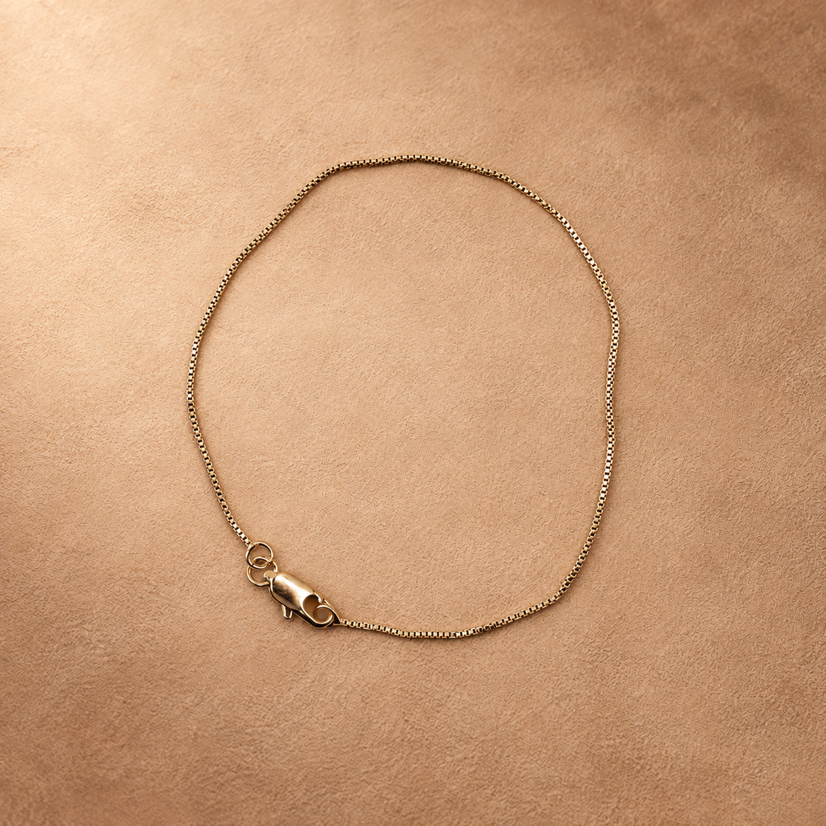 Linea 14K gold-plated steel bracelet arranged in an oval, showing the fine chain and lobster clasp.