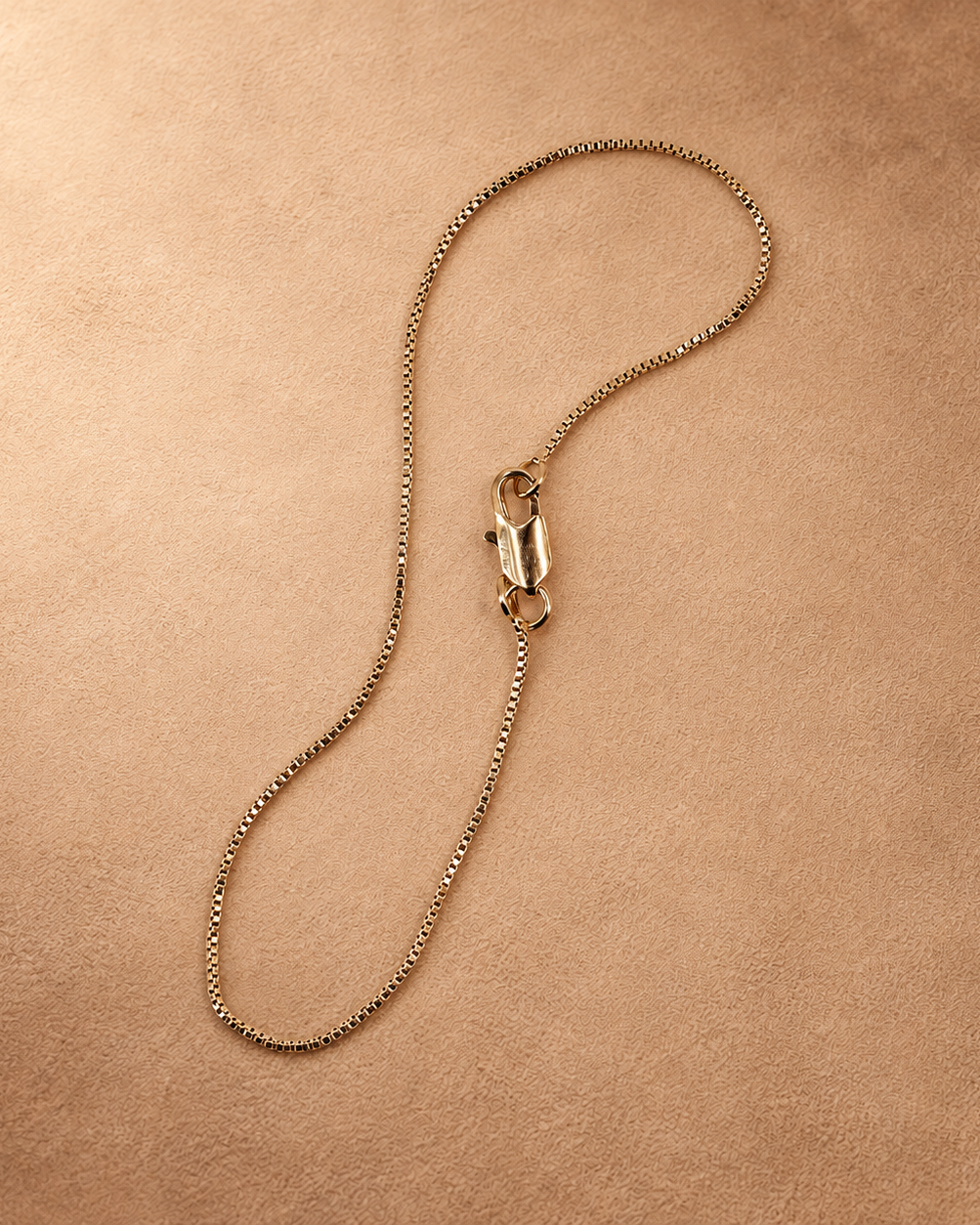 Linea bracelet in a looped arrangement, showing the small square chain links and polished lobster clasp.