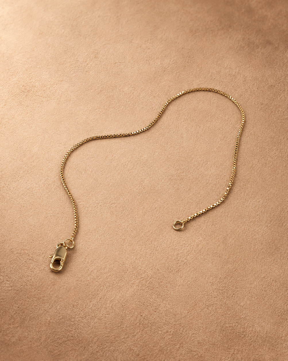 Angled view of Linea 14K gold-plated steel bracelet with the chain curved and clasp unfastened.