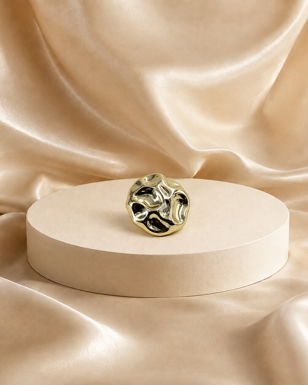 Front view of Onda 14K gold-plated steel stud earring, showing an irregular rounded outline and rippled polished surface.