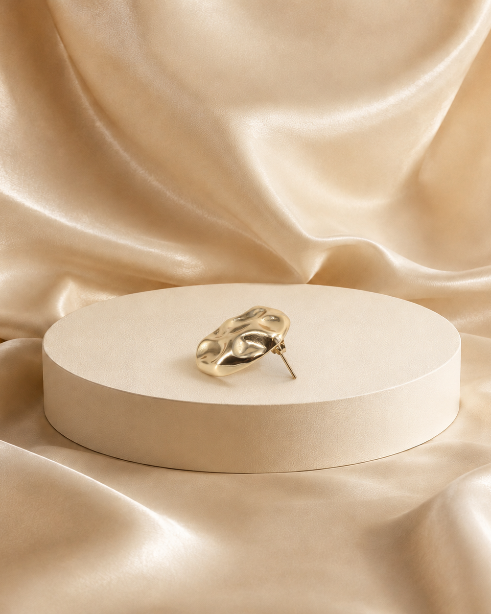 Onda sculptural stud earring at an angle, showing the softly raised surface and earring post.