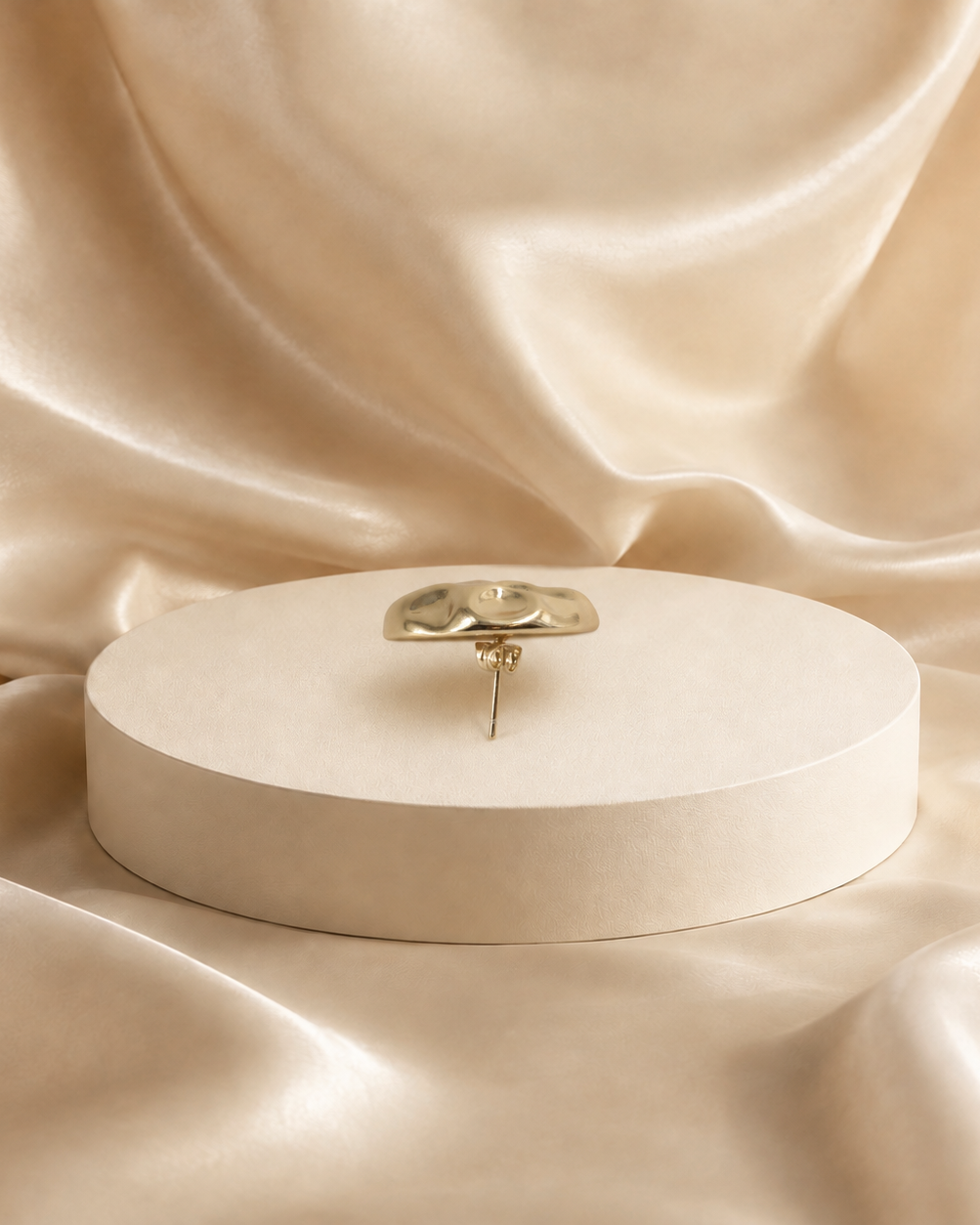 Side profile of Onda gold-plated stud earring, showing the domed face, straight post and backing.