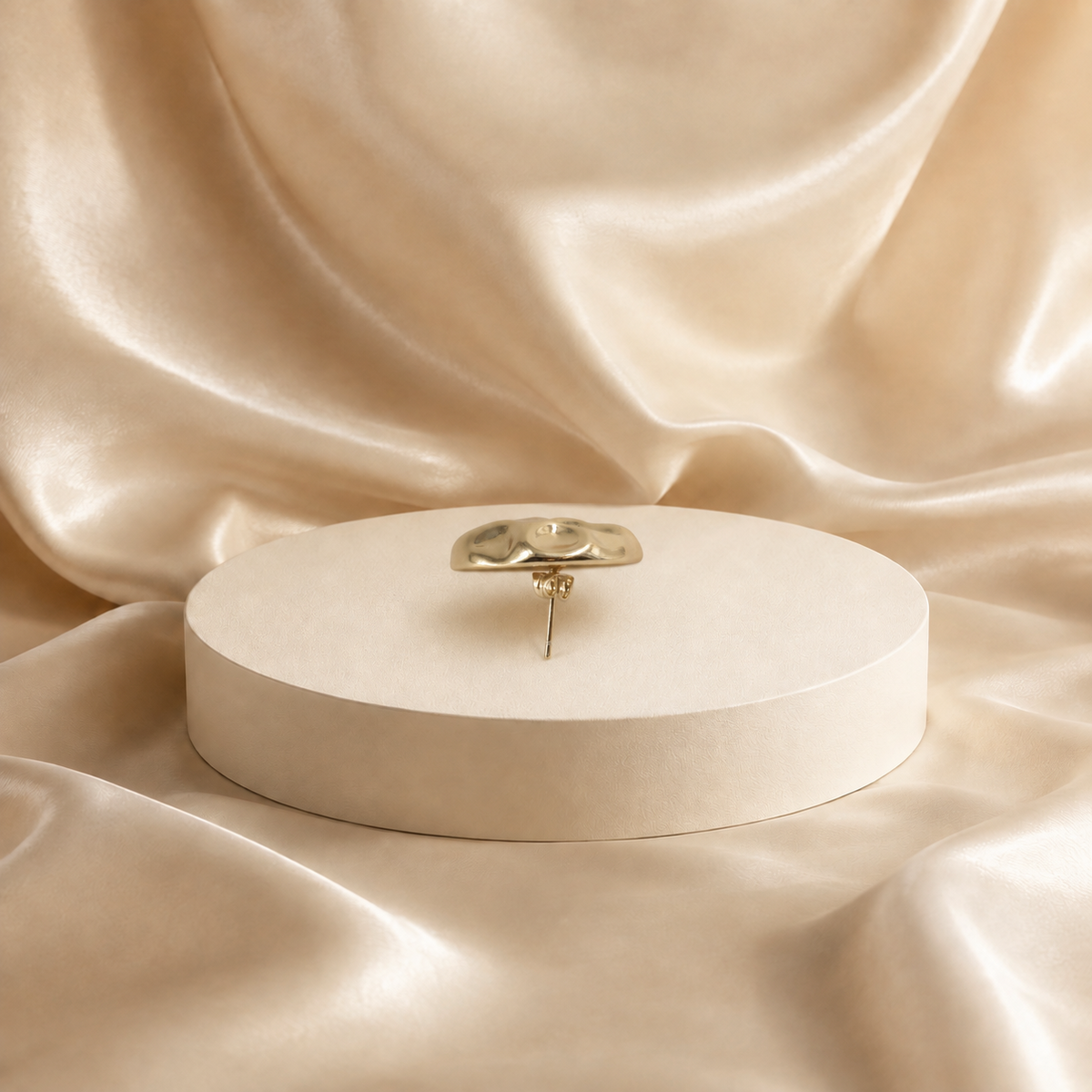 Side profile of Onda gold-plated stud earring, showing the domed face, straight post and backing.