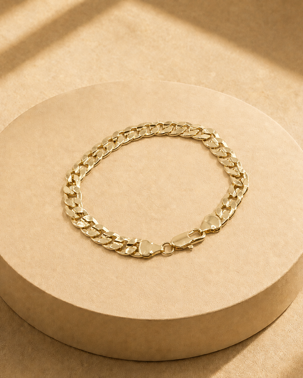 Riva 14K gold-plated steel curb chain bracelet arranged in an oval, showing polished flat links and a lobster clasp.