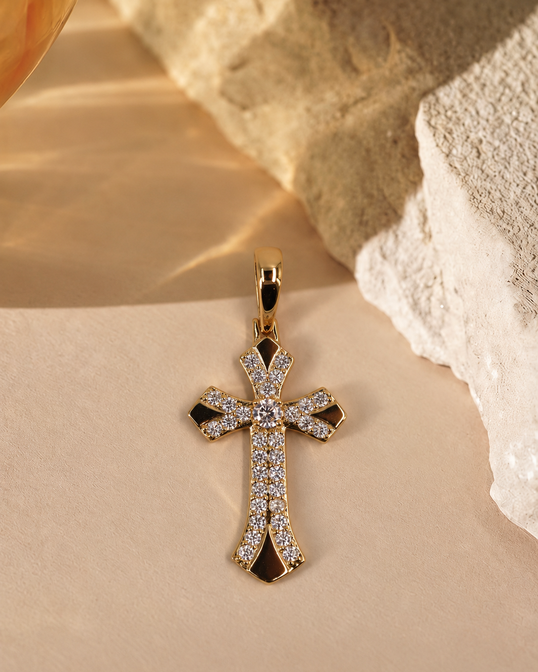 Front view of Seraphine 14K gold-plated steel cross pendant, with a round clear center accent and curved rows of smaller clear accents.