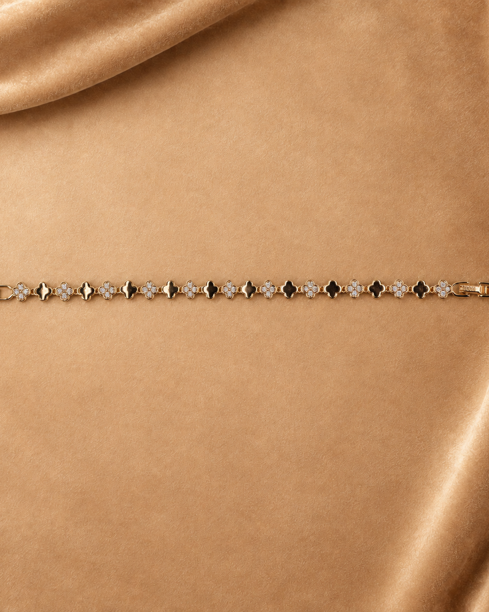 Sylvie gold-plated clover link bracelet laid straight with the clasp open, showing the full repeating pattern.