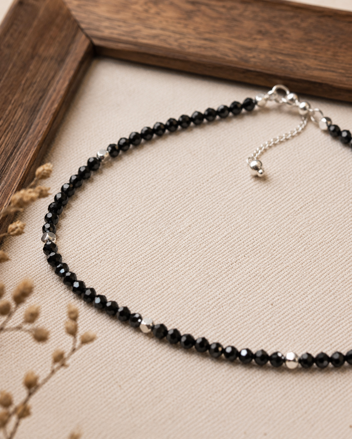 Close-up of brilliant-cut black spinel beads and sterling silver accents in Faceted Black Spinel Sterling Silver Long Necklace