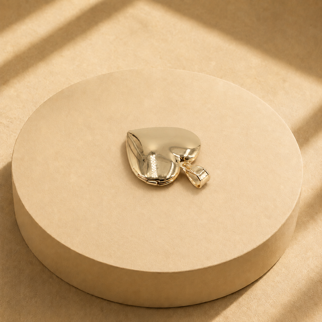 Back view of the Adora gold-plated heart pendant showing its smooth polished surface, edge seam and bail.