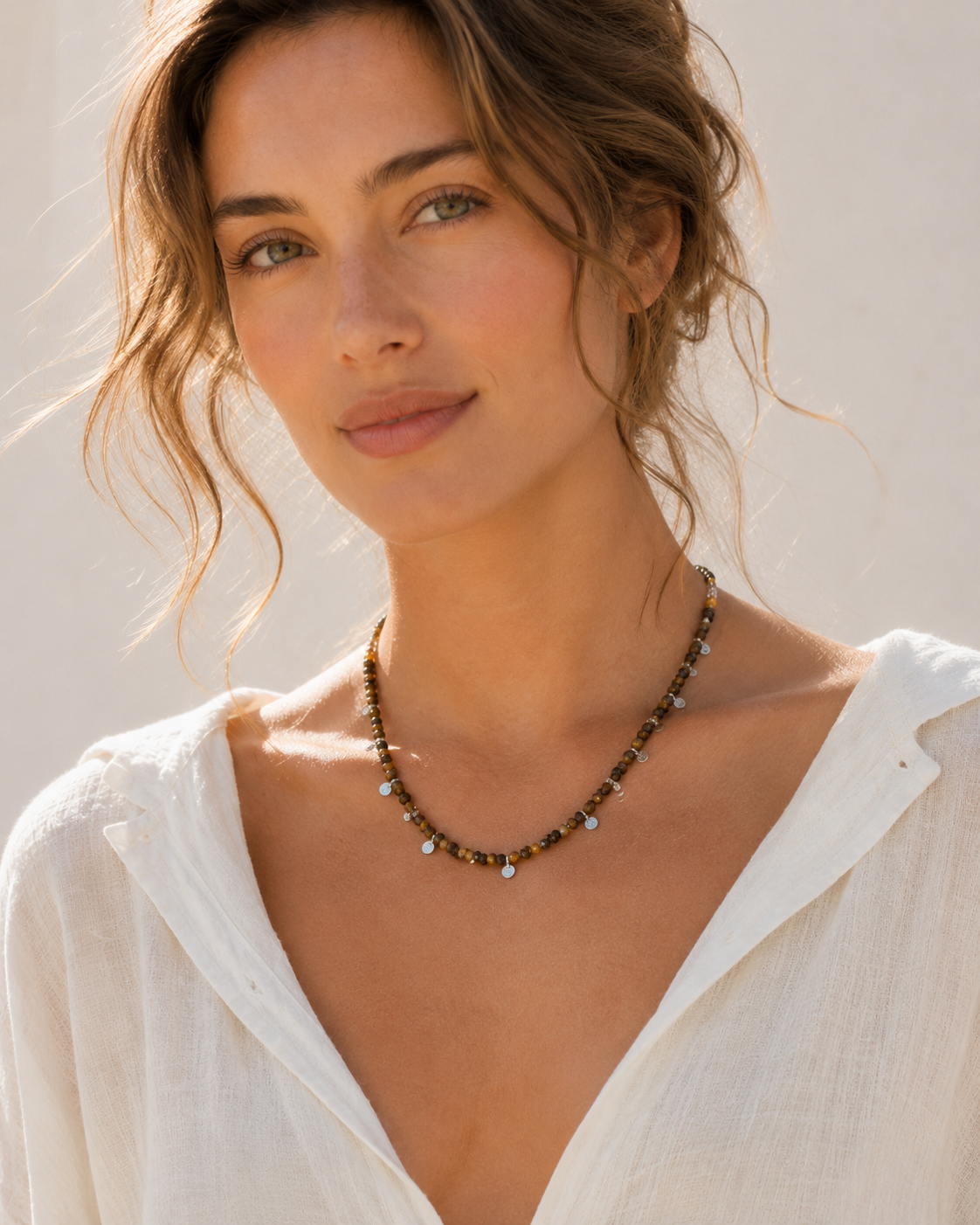 Model wearing Aurelia Tiger’s Eye Sterling Silver Charm Necklace with white linen summer outfit