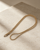 Corda 14K gold-plated steel rope chain necklace in an elongated loop, showing its twisted texture and lobster clasp.