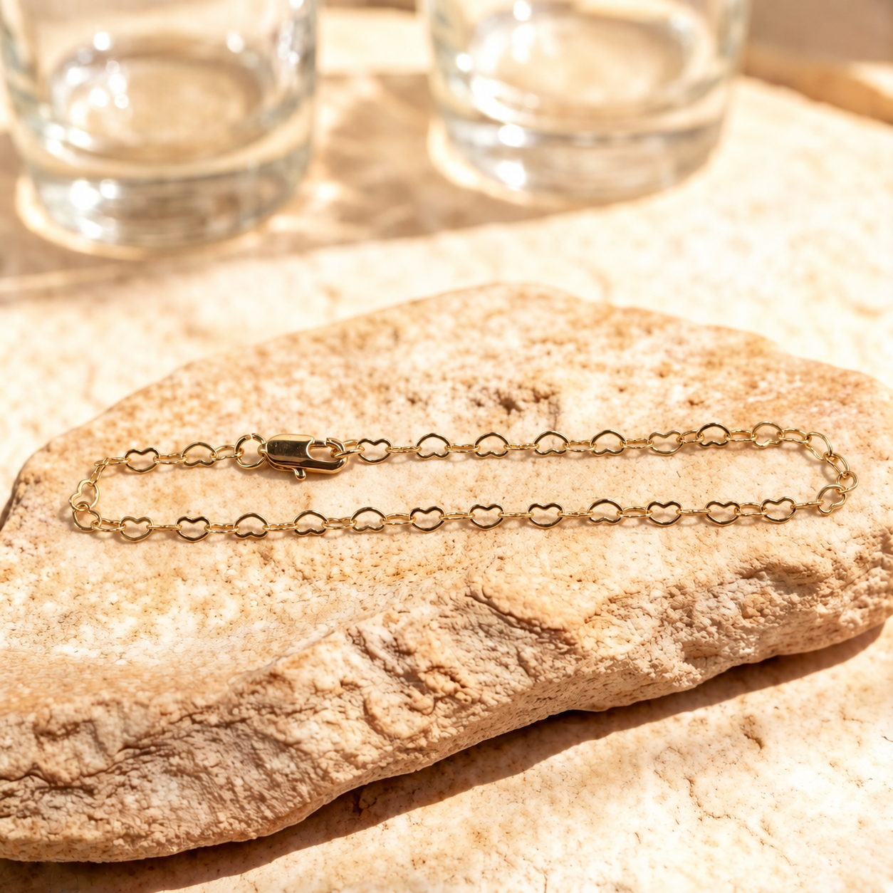 Esme 14K gold-plated steel bracelet arranged in a long oval, showing open heart links and a polished lobster clasp.