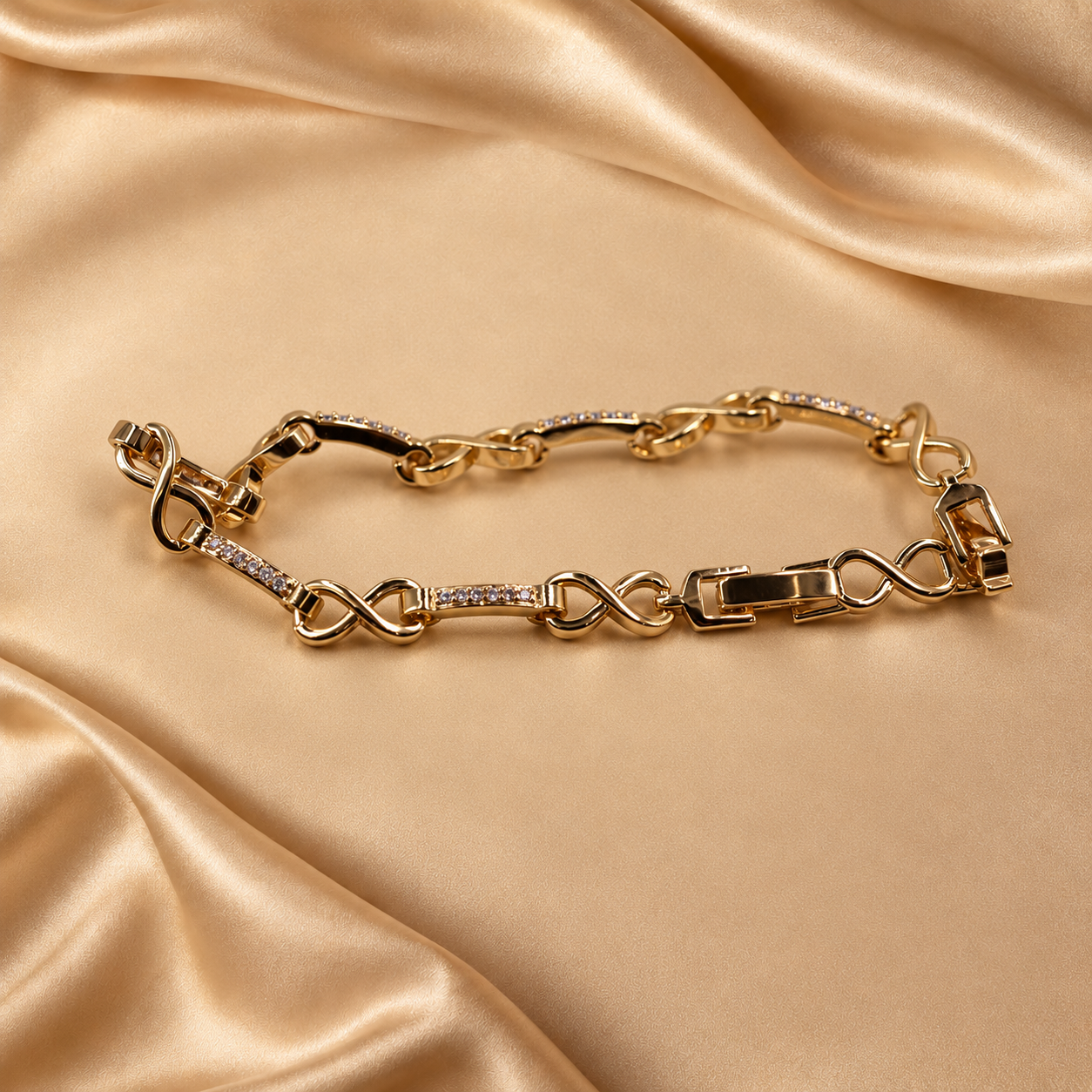 Low angled view of Evera gold-plated bracelet, highlighting curved infinity links, accented bars and the fold-over clasp.