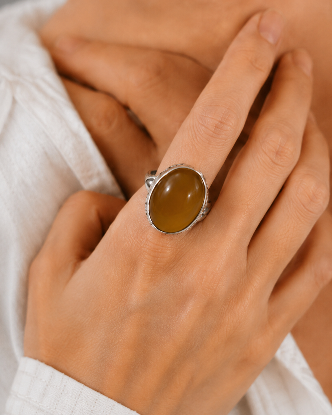 Close-up of honey amber cabochon and textured sterling silver setting in Honey Amber Sterling Silver Statement Ring