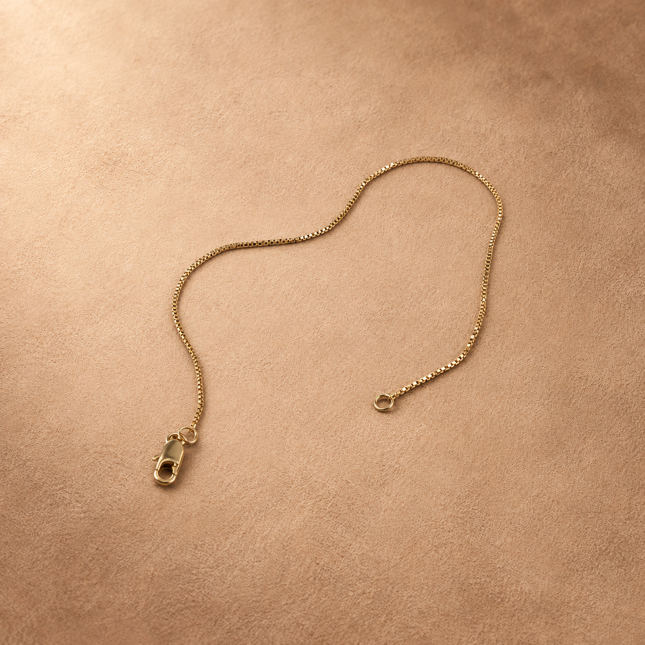 Angled view of Linea 14K gold-plated steel bracelet with the chain curved and clasp unfastened.