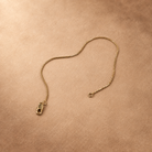 Angled view of Linea 14K gold-plated steel bracelet with the chain curved and clasp unfastened.
