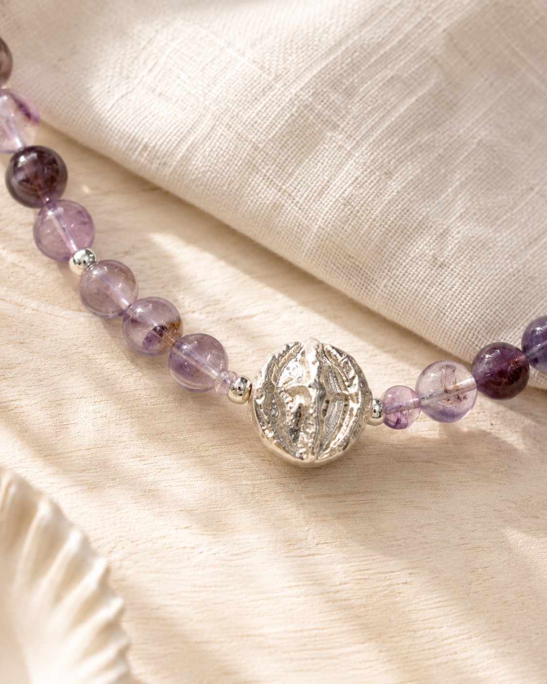 Close-up of purple phantom quartz beads, brushed sterling silver spacers, and sterling silver pendant in Luna Purple Phantom Quartz Pendant Necklace