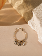 Nila 14K gold-plated steel hoop earring with three dangling elephant charms and polished round beads along the bottom.