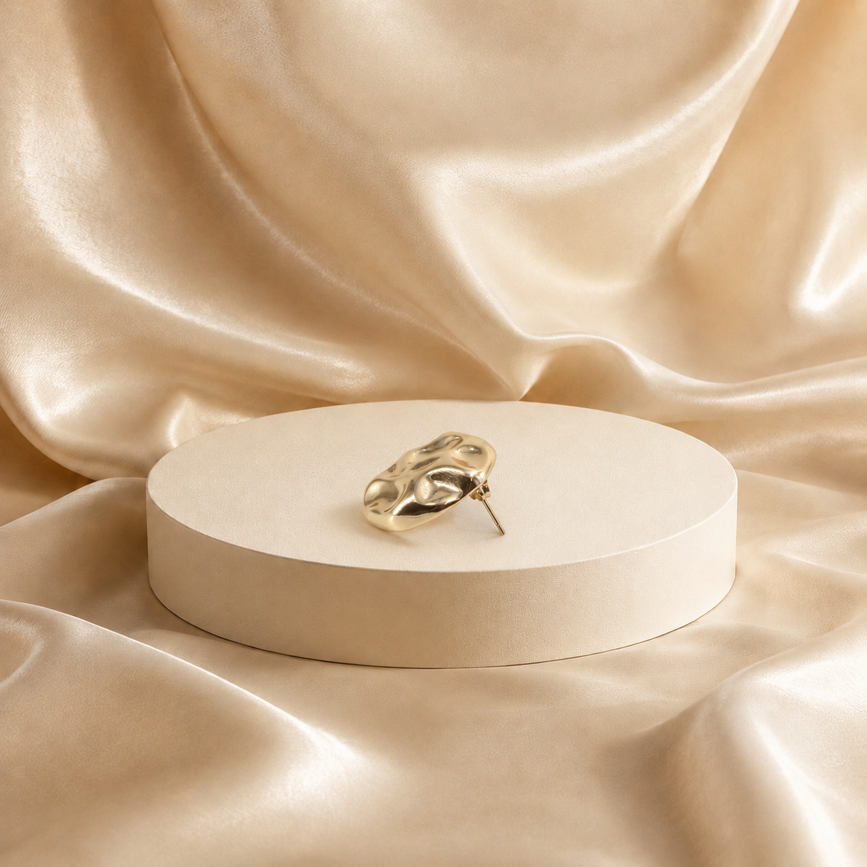 Onda sculptural stud earring at an angle, showing the softly raised surface and earring post.