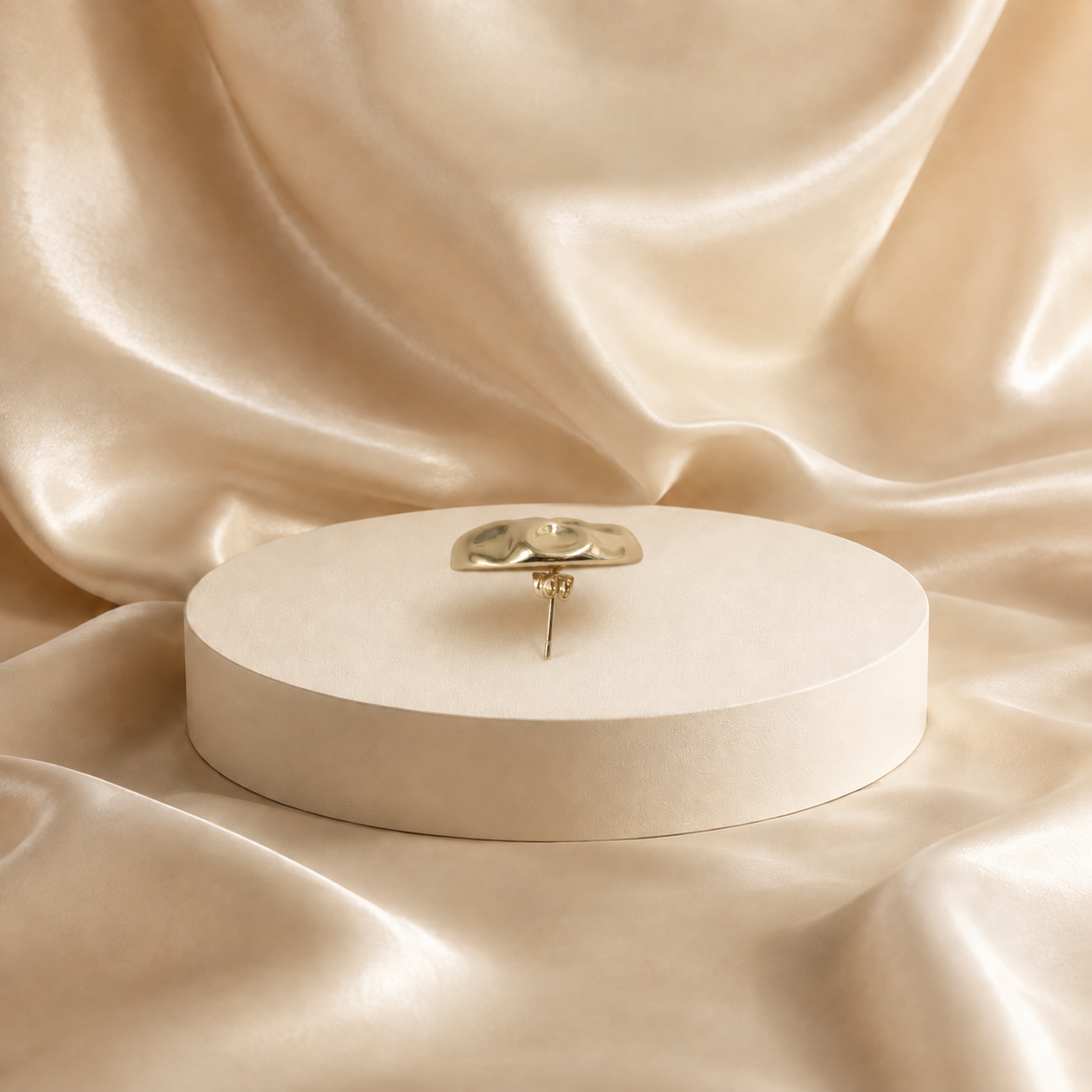 Side profile of Onda gold-plated stud earring, showing the domed face, straight post and backing.