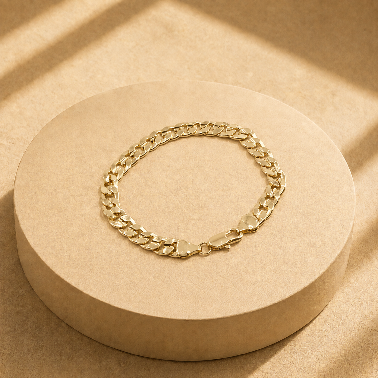 Riva 14K gold-plated steel curb chain bracelet arranged in an oval, showing polished flat links and a lobster clasp.