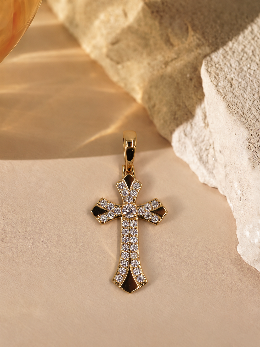 Front view of Seraphine 14K gold-plated steel cross pendant, with a round clear center accent and curved rows of smaller clear accents.